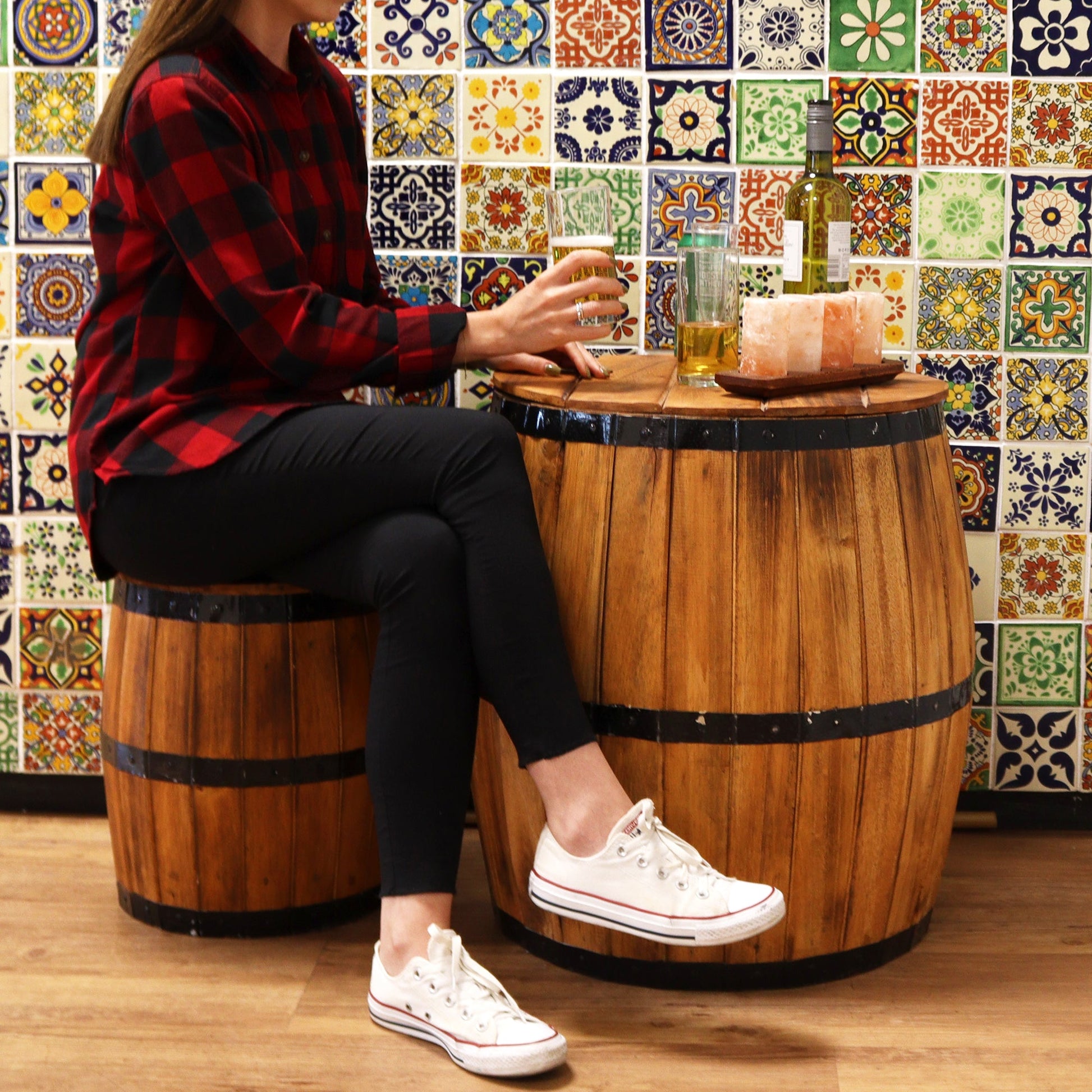 Albasia Wooden Beer Barrel Table - Whitewash, shown as a brown barrel table topped with drinks beside a seated person, by Quintessential Holistic Health Ltd