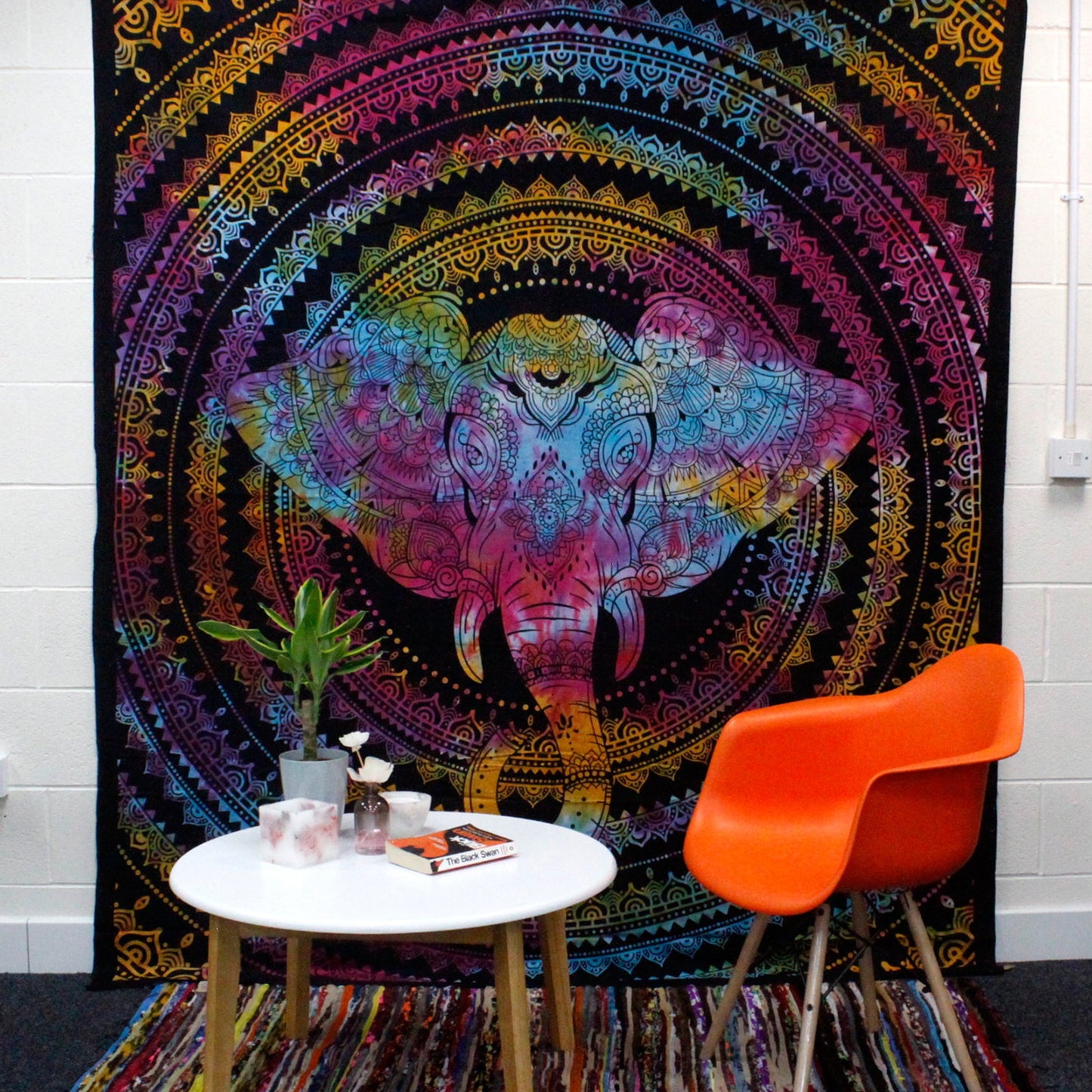 Double Cotton Wall Hanging or Bedspread - Elephant Head displayed behind an orange chair and white table by Quintessential Holistic Health Ltd