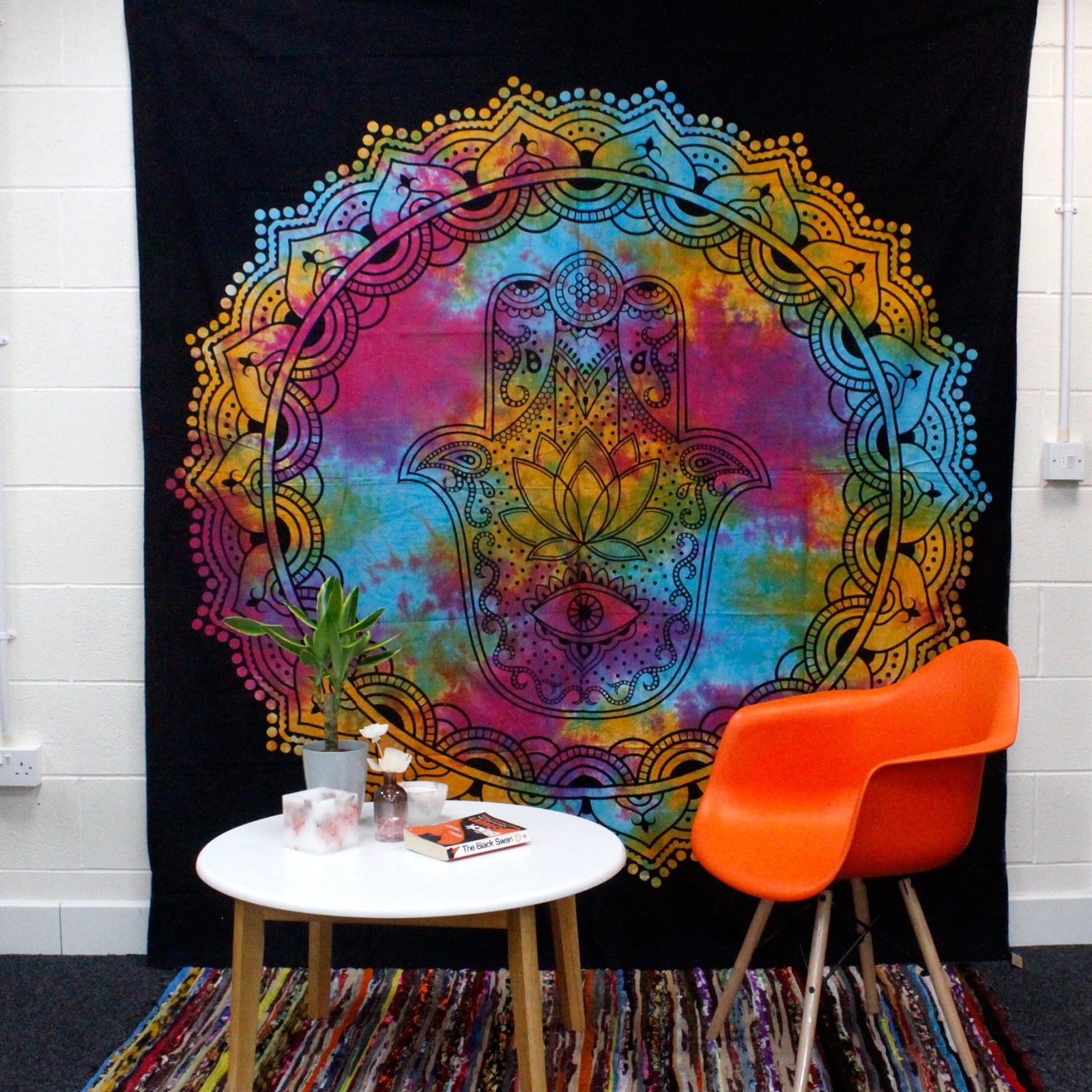 Cotton Wall Hanging or Bedspread - Double - Black Hamsa displayed behind an orange chair and white table by Quintessential Holistic Health Ltd