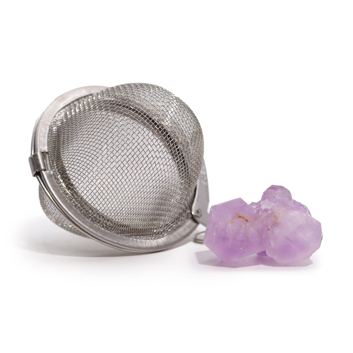 Amethyst Cluster Raw Gemstone Tea Strainer, Serenity & Calm with an open mesh ball beside a pale purple crystal cluster by Quintessential Holistic Health Ltd