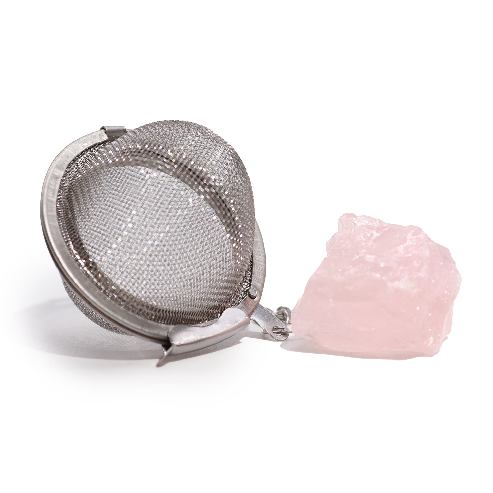 Raw Crystal Tea Strainer - Rose Quartz, Love with an open silver mesh ball beside a large rough pale pink stone by Quintessential Holistic Health Ltd
