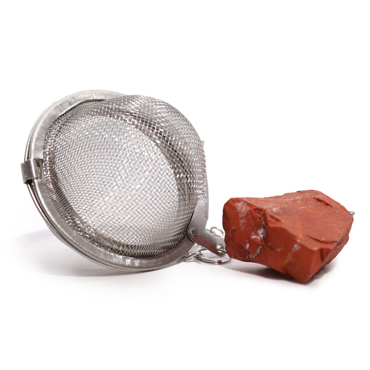 Raw Crystal Gemstone Tea Strainer – Red Jasper, Joy with an open silver mesh ball beside a chunky rust-red stone by Quintessential Holistic Health Ltd