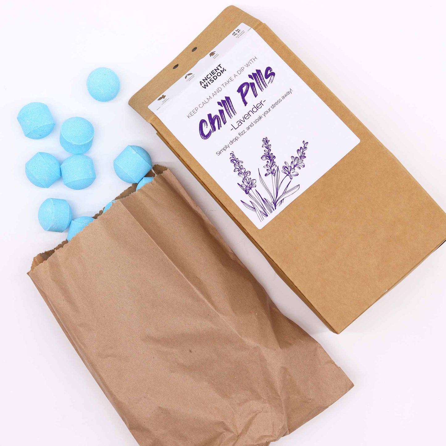 Vegan Bath Bomb Chill Pills Gift Pack - Lavender - 350g, open kraft box beside a paper bag and scattered pale blue tablets, by Quintessential Holistic Health Ltd