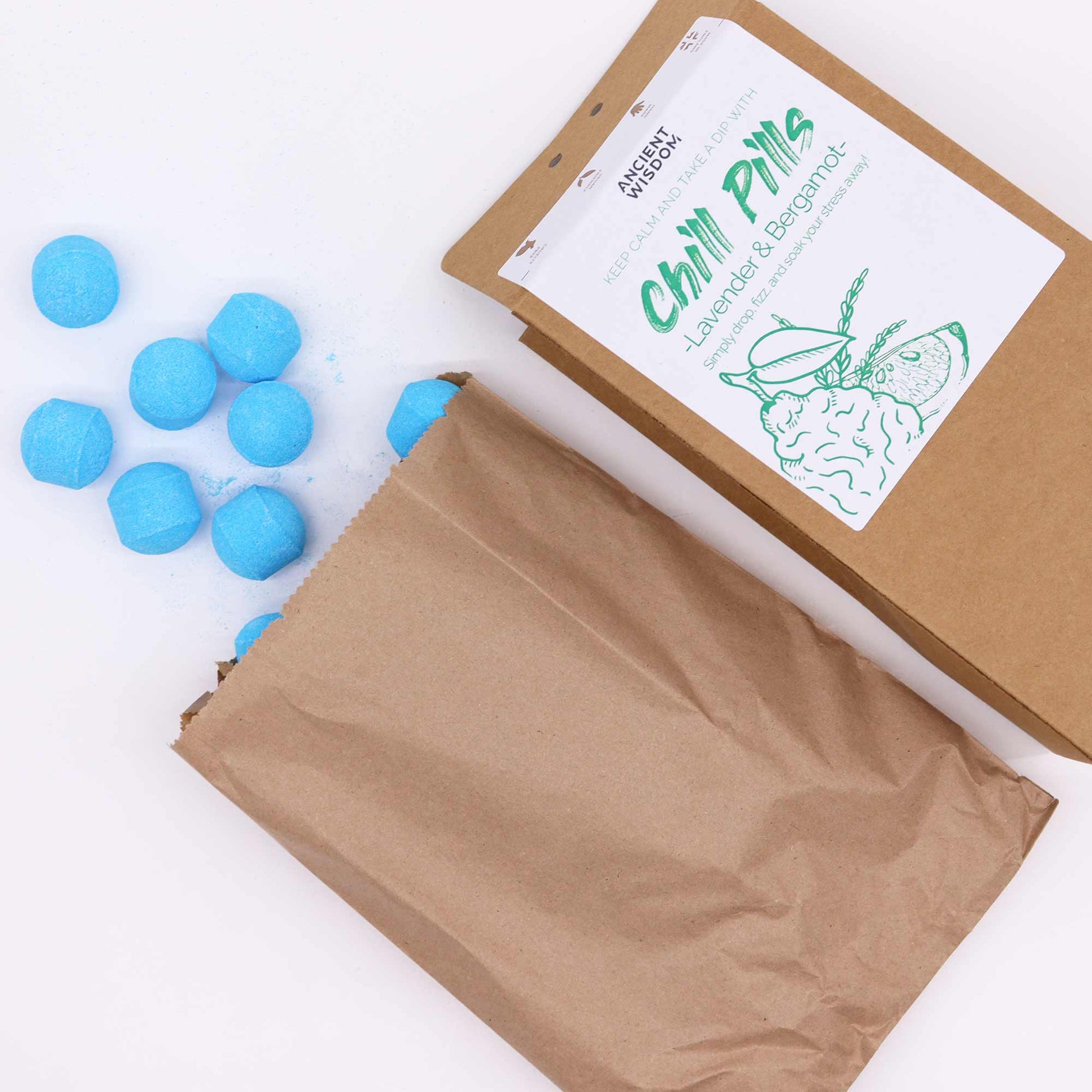 Vegan Bath Bomb Chill Pills - Lavender & Bergamot - 350g, open kraft box beside a paper bag and scattered bright blue tablets, by Quintessential Holistic Health Ltd