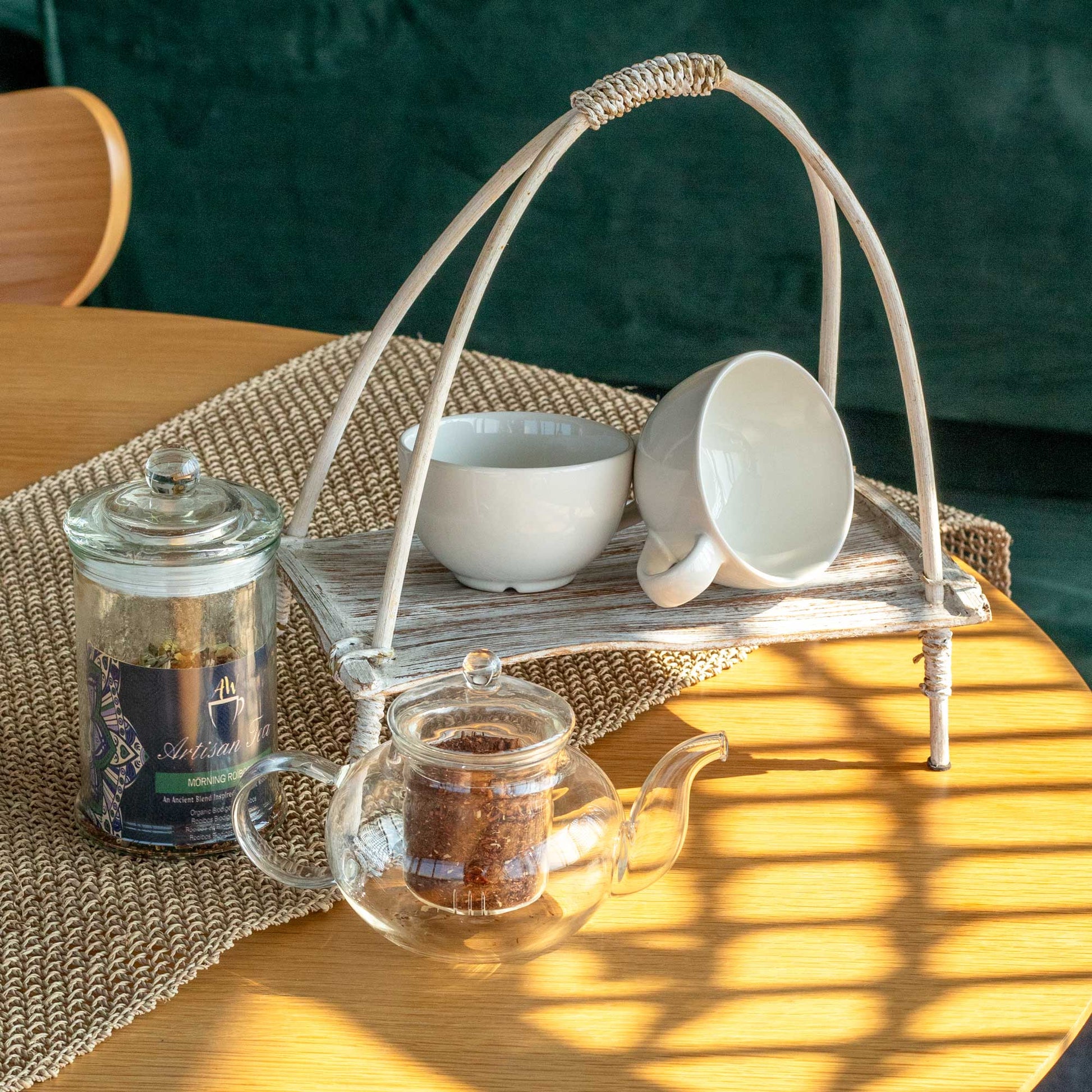 Coconut Leaf Tea Stand - Whitewash, arched supports and woven platform with white crockery and folded napkins by Quintessential Holistic Health Ltd