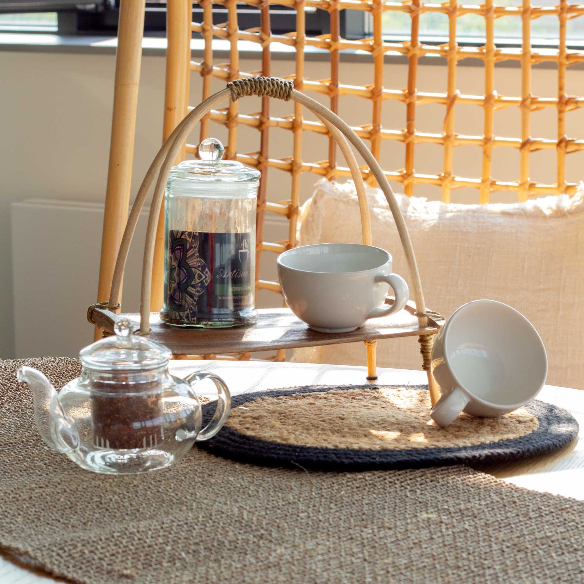Coconut Leaf Tea Stand - Natural holding a glass jar and white cup beside a clear glass teapot by Quintessential Holistic Health Ltd