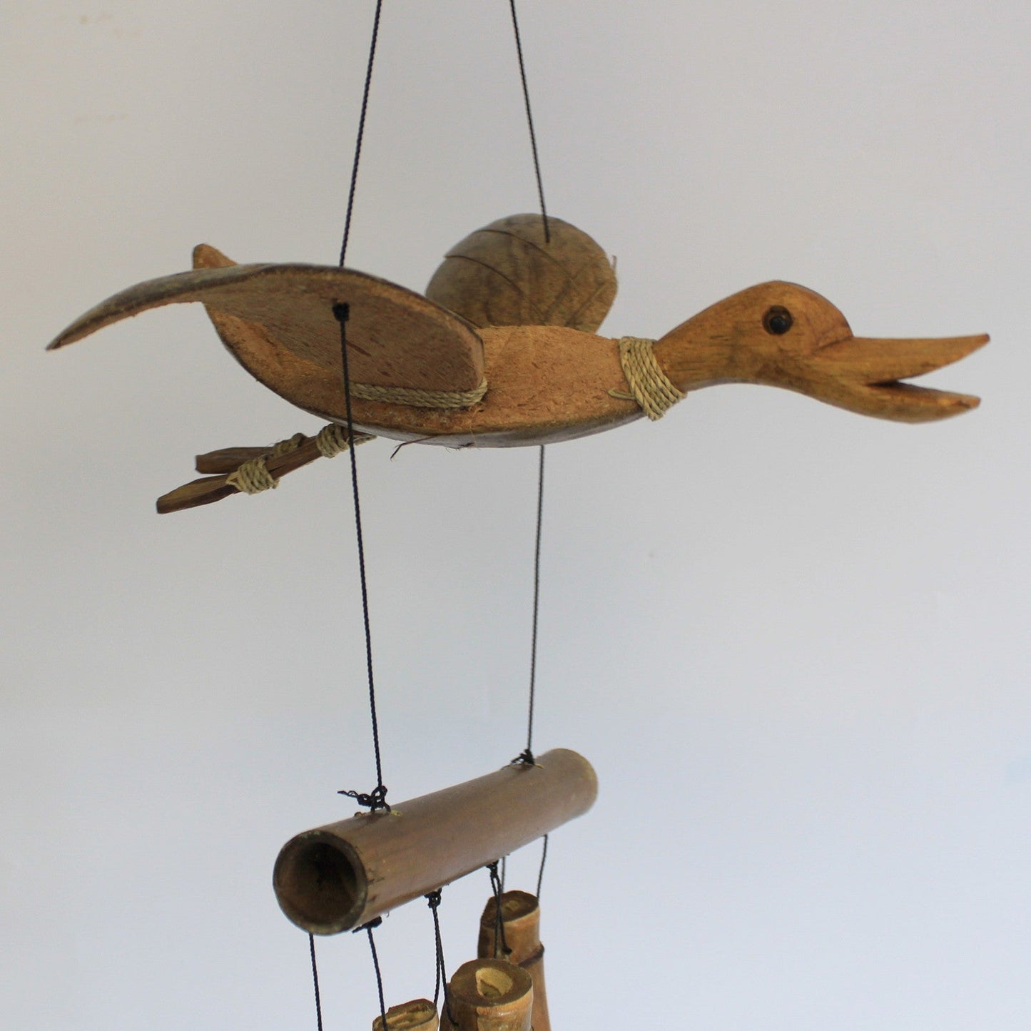Handcrafted Coconut Shell and Bamboo Wind Chime - Duck, flying duck ornament above a horizontal bamboo tube and hanging shells by Quintessential Holistic Health Ltd