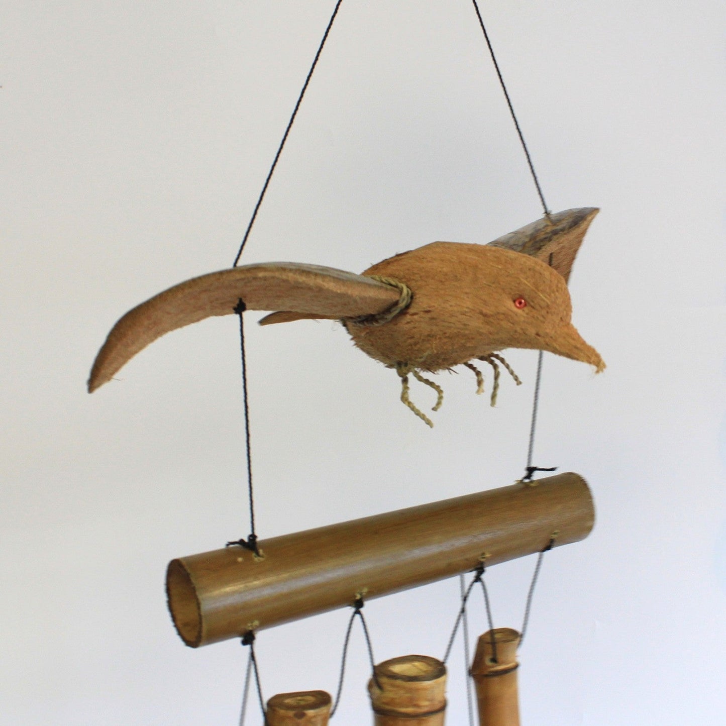 Handcrafted Coconut Shell and Bamboo Wind Chime - Blackbird, suspended bird with spread wings above a horizontal tube and chimes by Quintessential Holistic Health Ltd