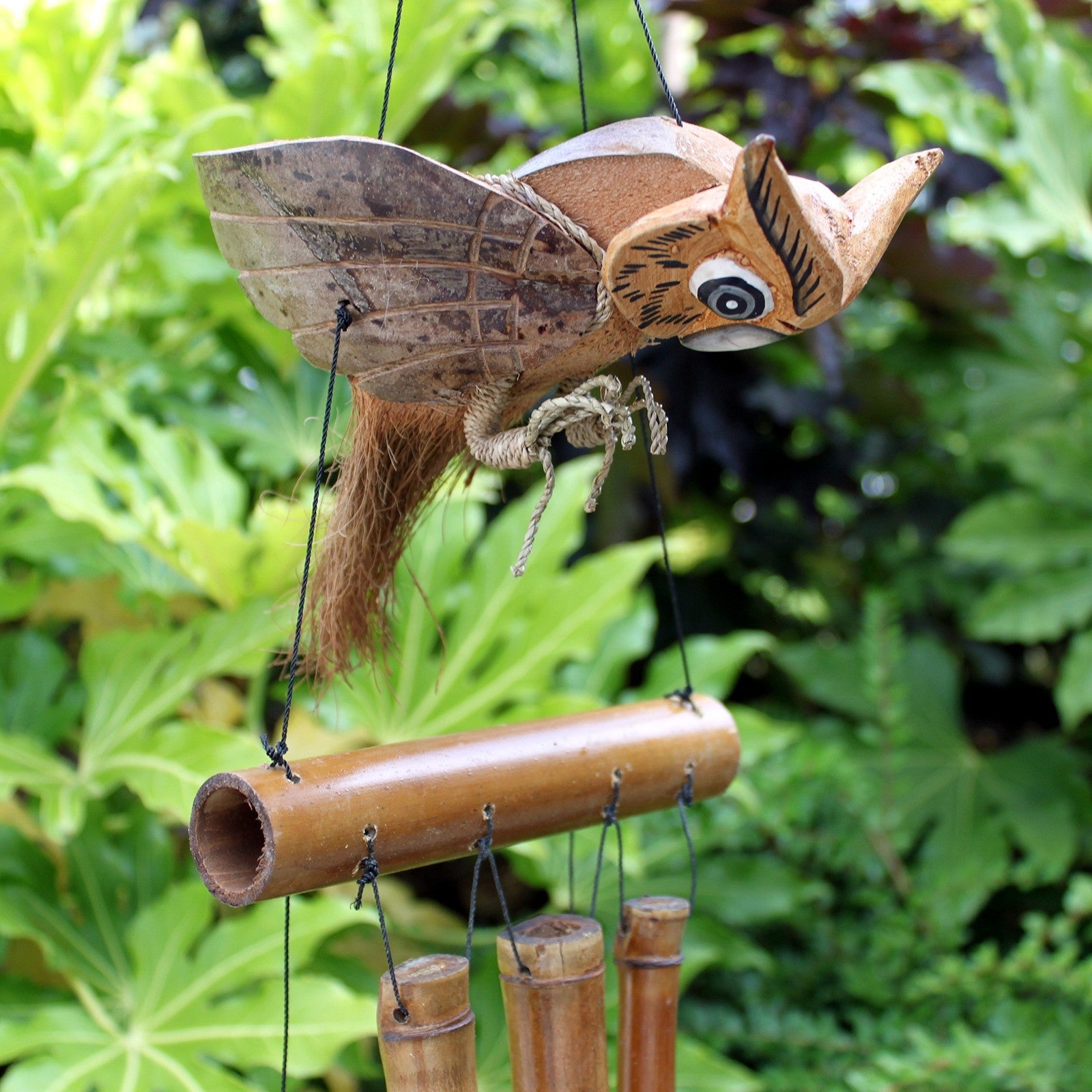 Handcrafted Coconut Shell and Bamboo Wind Chime - Owl among greenery with spread wings above hanging brown tubes by Quintessential Holistic Health Ltd