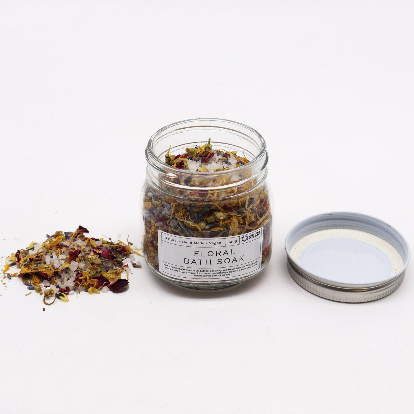 Natural Floral Bath Soak - 140g, open labelled glass jar with dried botanicals and its silver lid beside it by Quintessential Holistic Health Ltd