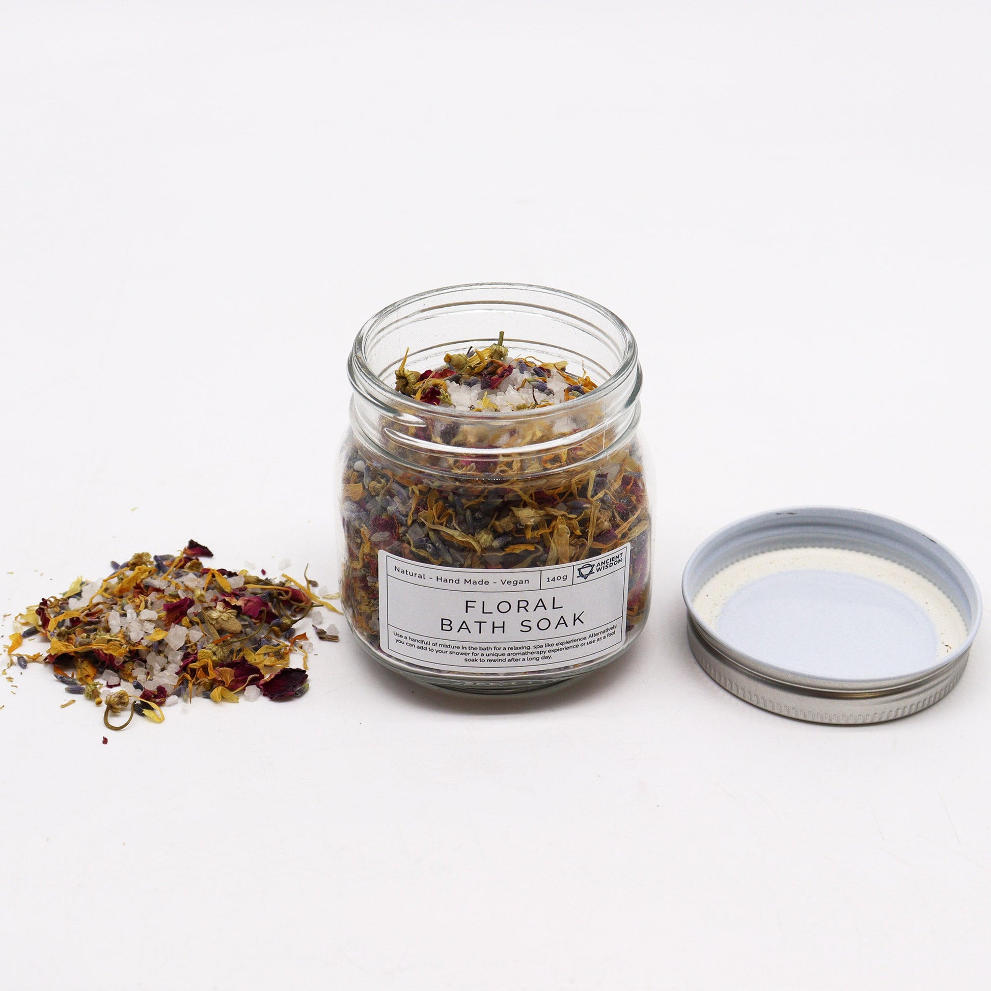 Natural Floral Bath Soak - 140g, open labelled glass jar with dried botanicals and its silver lid beside it by Quintessential Holistic Health Ltd