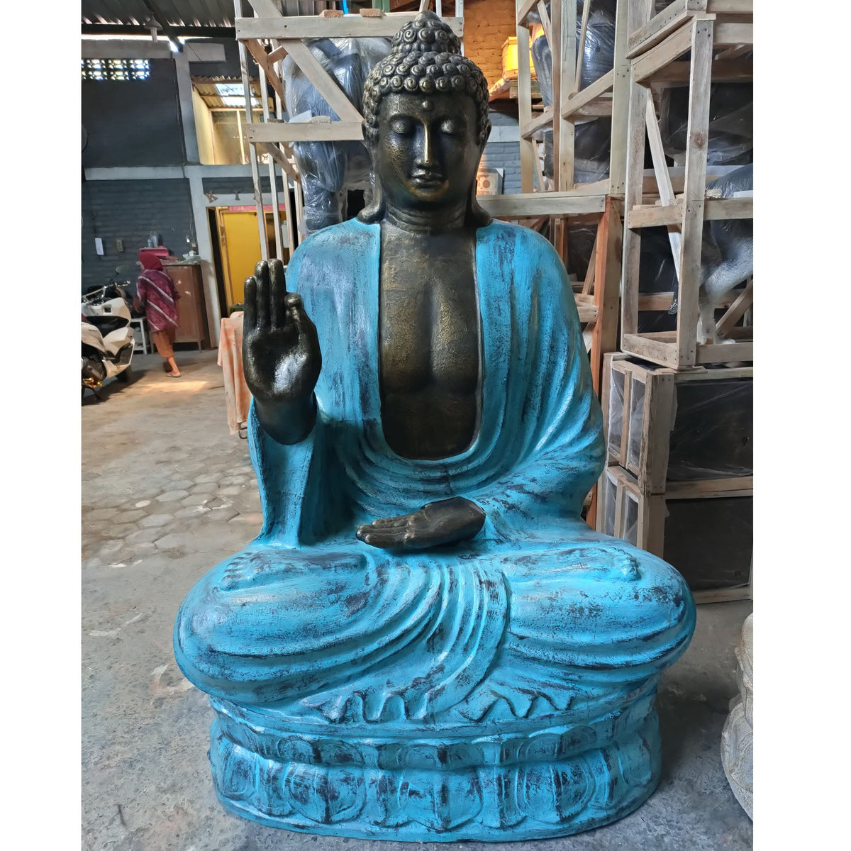 Concrete & Resin Buddha Teaching Lotus Statue - 2m Turquoise & Stone, Buddha with turquoise robe and raised hand displayed in a workshop by Quintessential Holistic Health Ltd