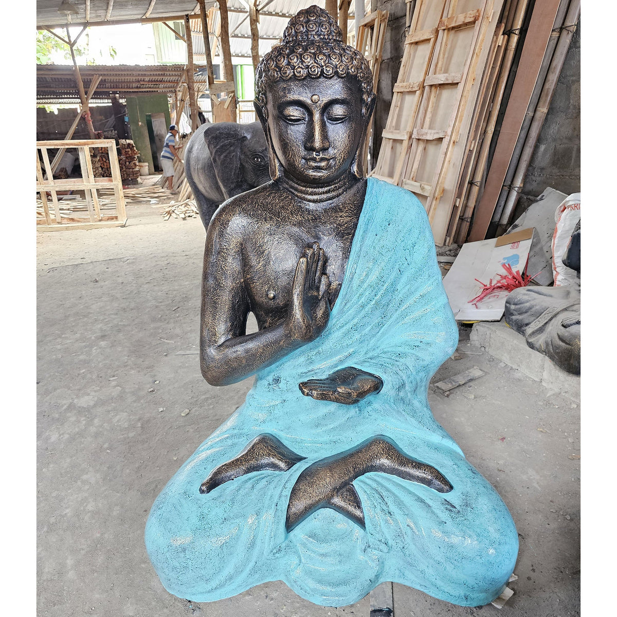 Concrete & Resin Buddha Stupa Statue - 1.5m Turquoise & Stone, seated Buddha with turquoise robe displayed in a workshop by Quintessential Holistic Health Ltd