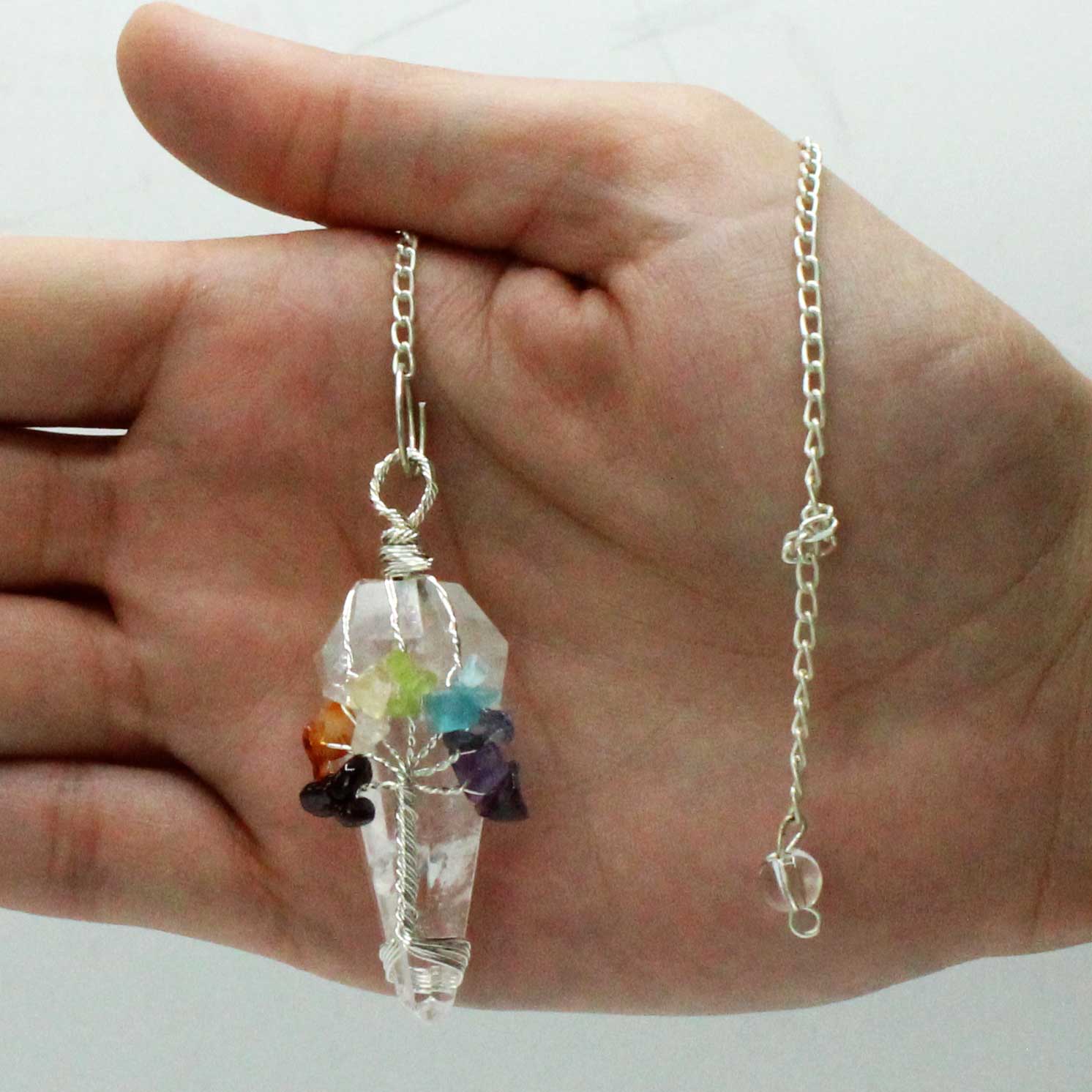 1 x Handmade Magic Radiesthesia Pendulum - Seven Chakra / Rock Quartz Gemstone product packaging on clean background from Quintessential Holistic Health Ltd
