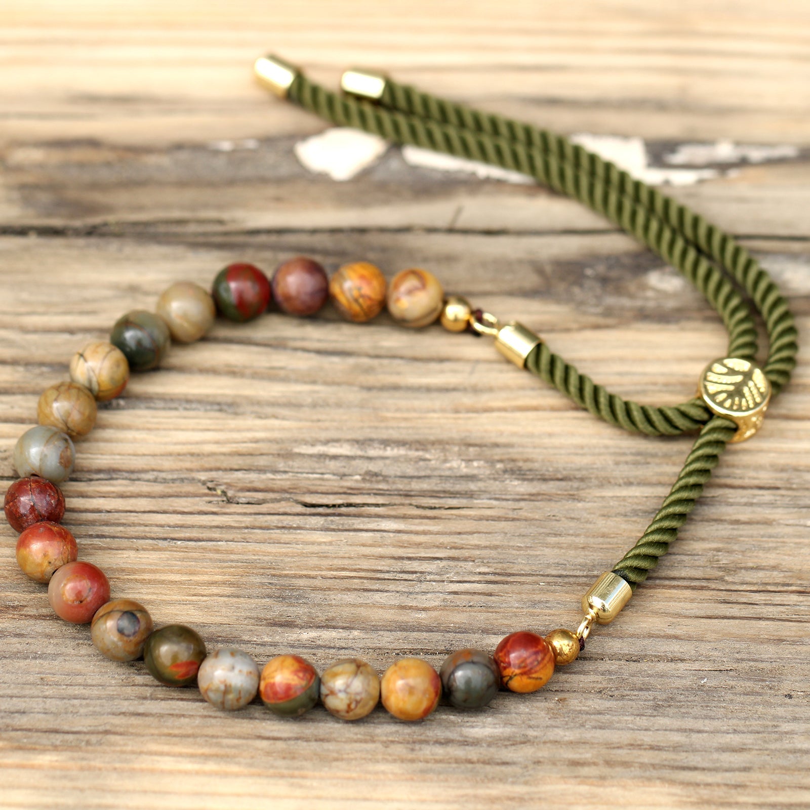 Unisex Handcrafted 18K Gold Plated Gemstone Bracelet - Moss Green String / Picasso Jasper product packaging on clean background from Quintessential Holistic Health Ltd