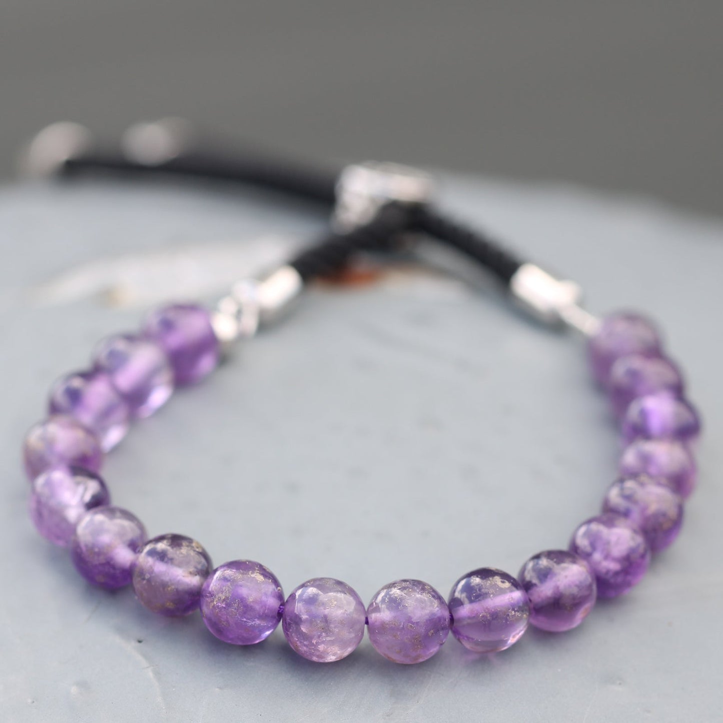 Unisex Handcrafted 925 Silver Plated Gemstone Bracelet - Black String / Amethyst product packaging on clean background from Quintessential Holistic Health Ltd