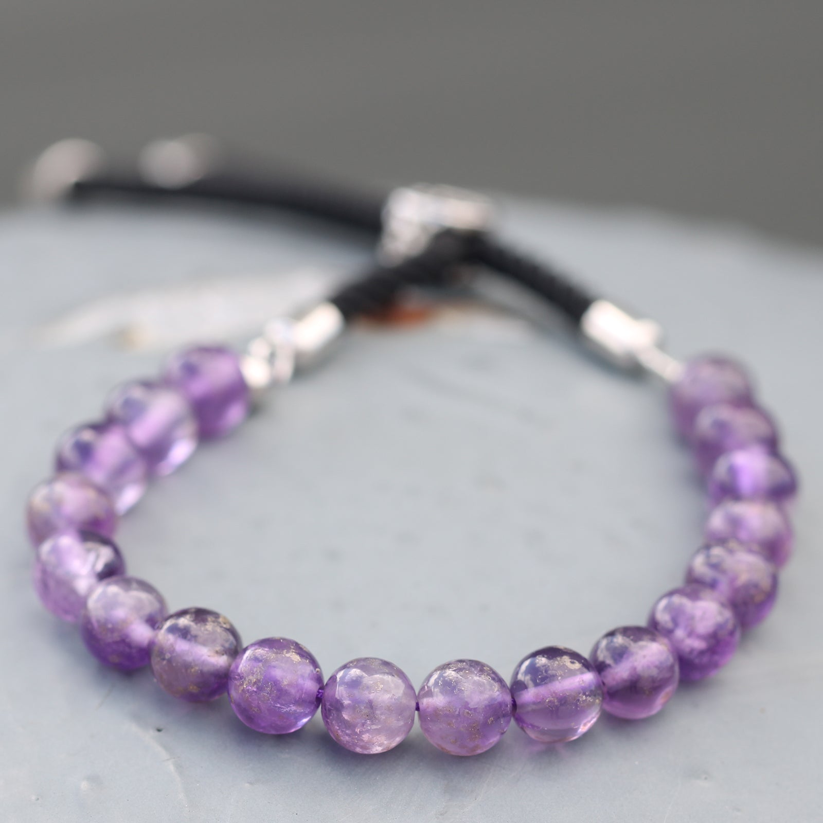 Unisex Handcrafted 925 Silver Plated Gemstone Bracelet - Black String / Amethyst product packaging on clean background from Quintessential Holistic Health Ltd