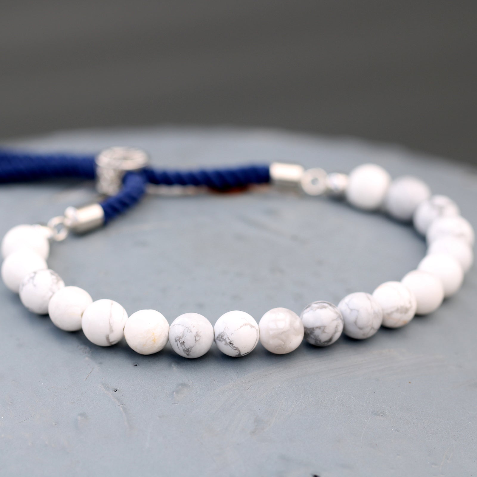 Unisex Handcrafted 925 Silver Plated Gemstone Bracelet - Navy Blue String / White Howlite product packaging on clean background from Quintessential Holistic Health Ltd