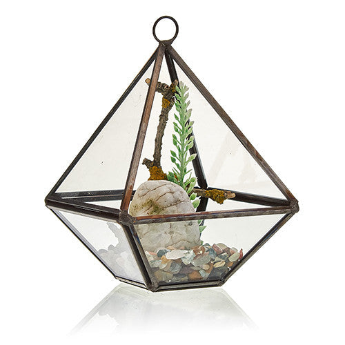 Small Glass and Brass Diamond Terrarium holding pale stones, a shell, greenery and a twig by Quintessential Holistic Health Ltd