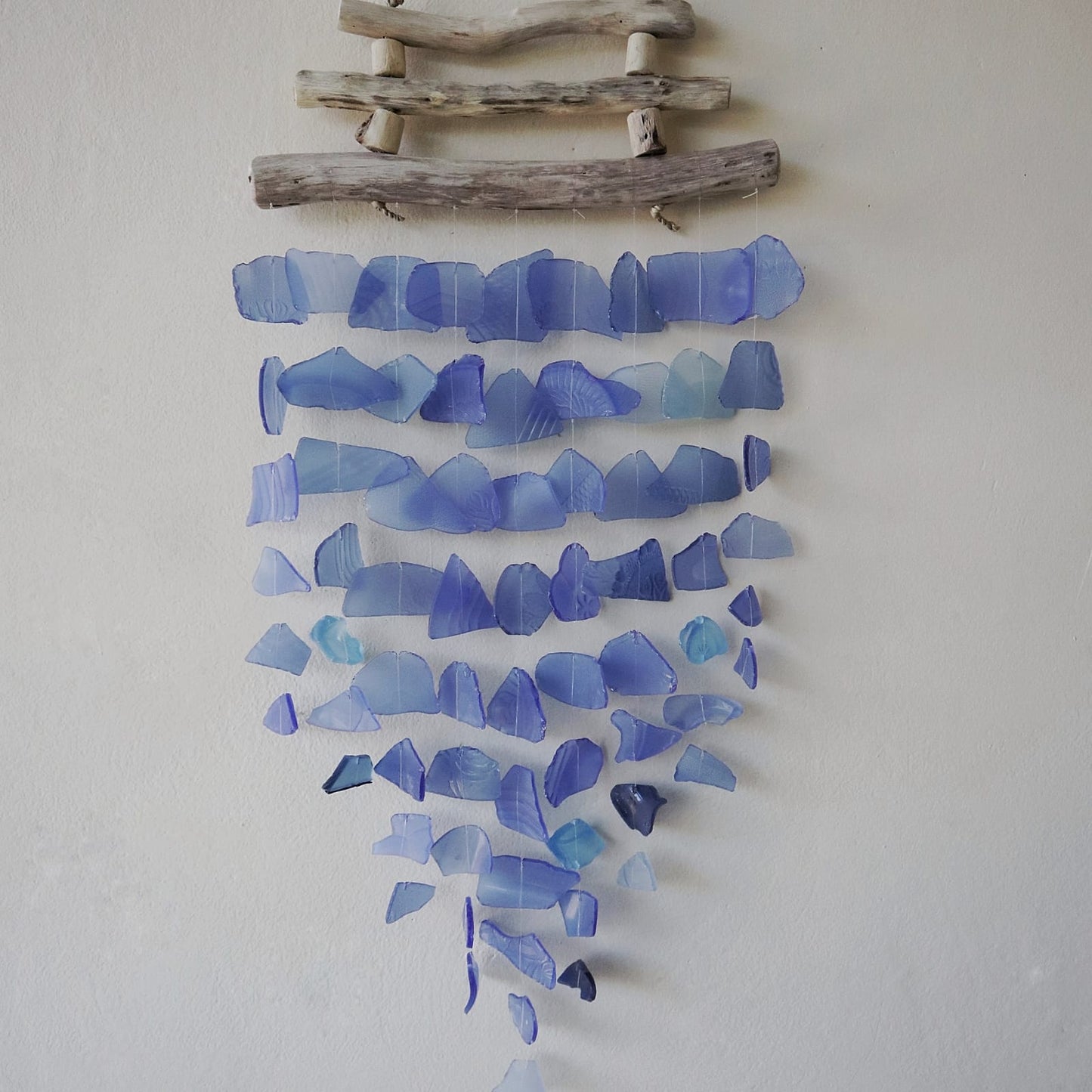 Driftwood & Recycled Glass Wind Chime - Three-Stick Blue, rows of blue glass pieces tapering to a point beneath driftwood by Quintessential Holistic Health Ltd
