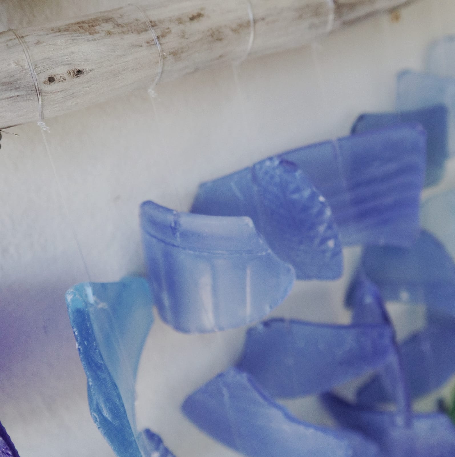 Driftwood & Recycled Glass Wind Chime - Three-Stick Blue, close-up of blue glass pieces threaded on clear strands by Quintessential Holistic Health Ltd