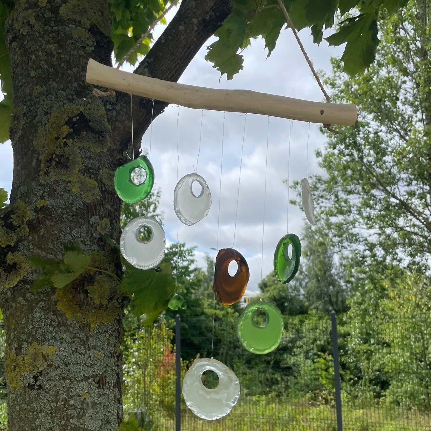 Handmade Driftwood and Recycled Glass Wind Chime - Bottle Bottoms / Multicoloured product packaging on clean background from Quintessential Holistic Health Ltd