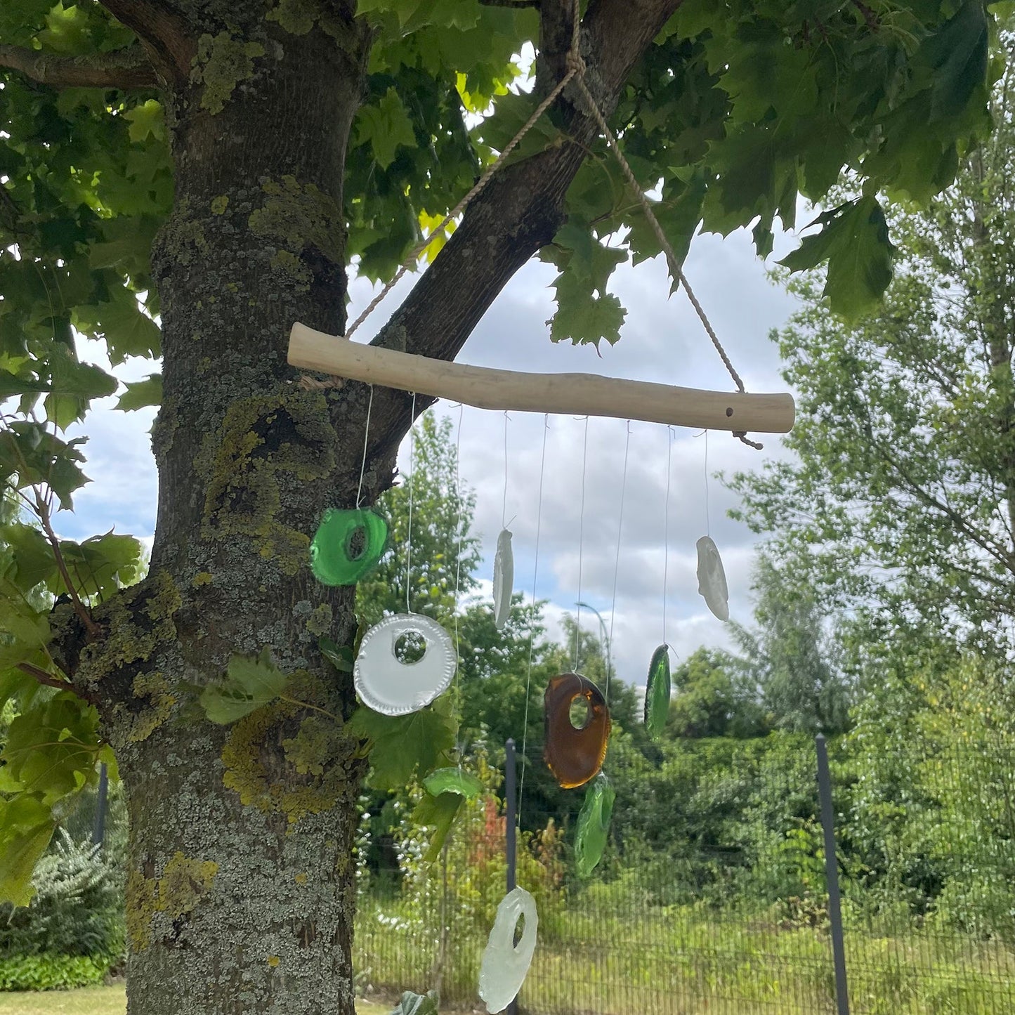 Handmade Driftwood and Recycled Glass Wind Chime - Bottle Bottoms / Multicoloured product packaging on clean background from Quintessential Holistic Health Ltd