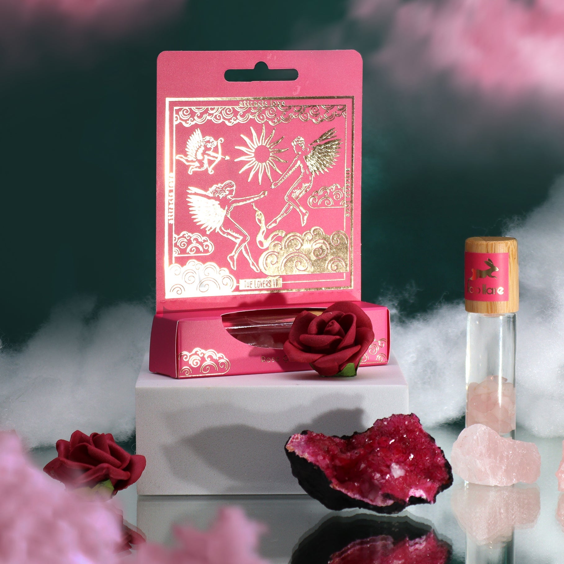 Gemstone Tarot Essential Oil Roll-On - Rose Quartz - The Lovers displayed with a pink box, clear bottle and red flowers by Quintessential Holistic Health Ltd
