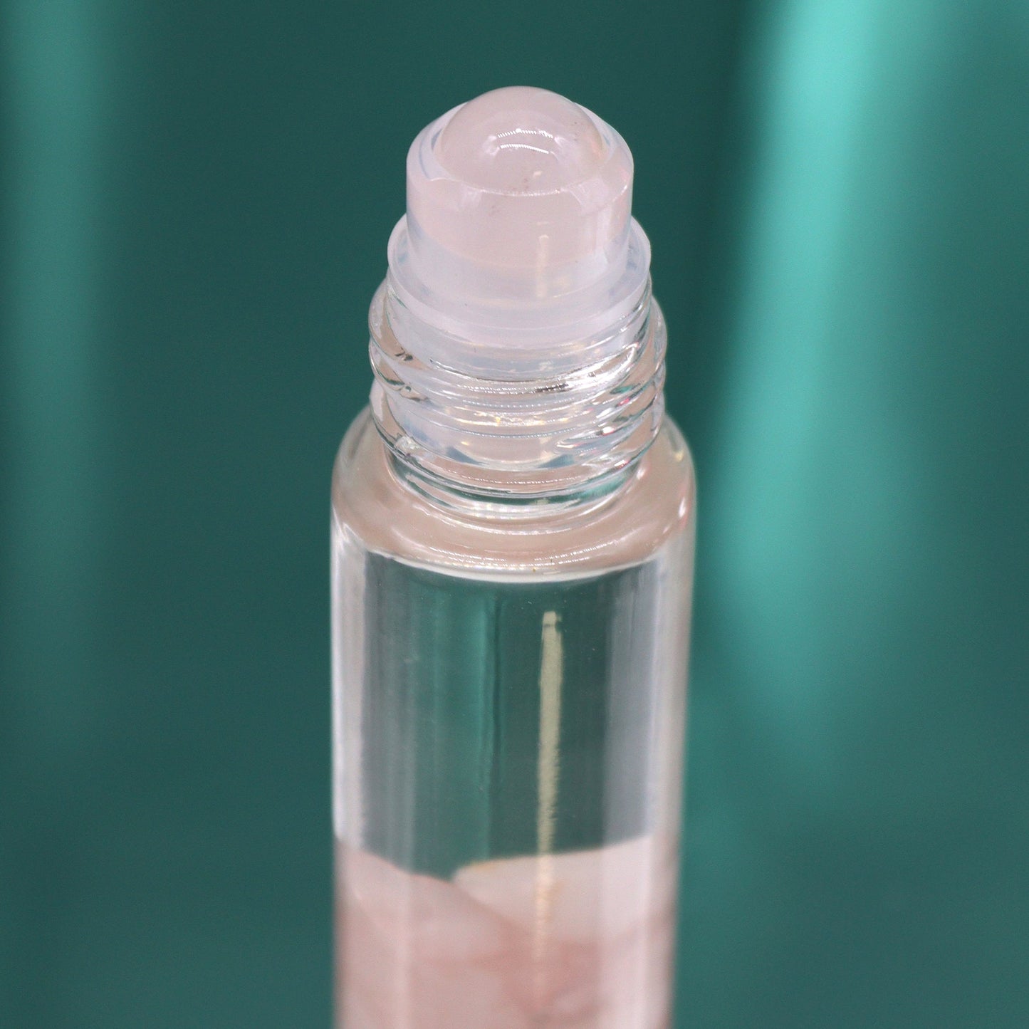 Gemstone Tarot Essential Oil Roll-On - Rose Quartz - The Lovers showing a pale roller top above pink chips by Quintessential Holistic Health Ltd