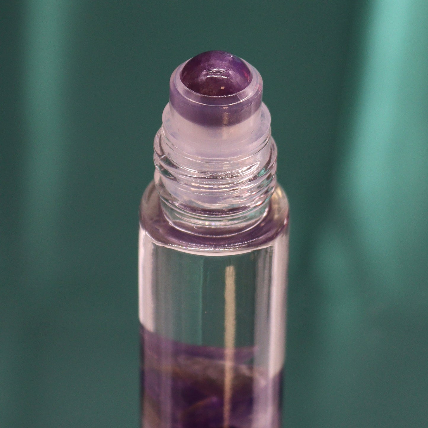Gemstone Tarot Essential Oil Roll-On - Amethyst - The Moon showing the purple roller top above violet stones by Quintessential Holistic Health Ltd