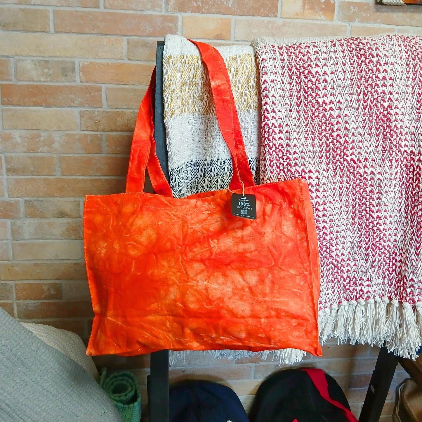 Handmade 100% Natural Cotton Handy Bag - Desert Orange Stonewash with cloudy orange patterning and a black hanging tag by Quintessential Holistic Health Ltd