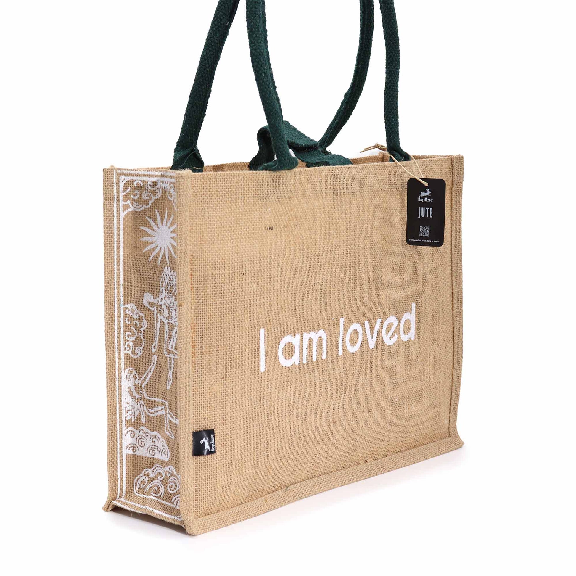 Eco-Friendly Jute Tote Bag - I Am Loved, with white affirmation text and sun-and-figure side artwork by Quintessential Holistic Health Ltd