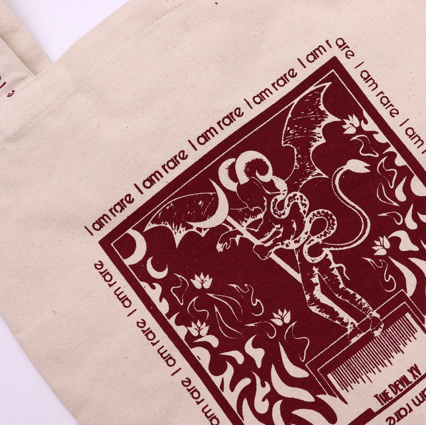 Devil Tarot Card Cotton Canvas Tote Bag - I Am Rare with a close-up burgundy illustration of a horned figure by Quintessential Holistic Health Ltd