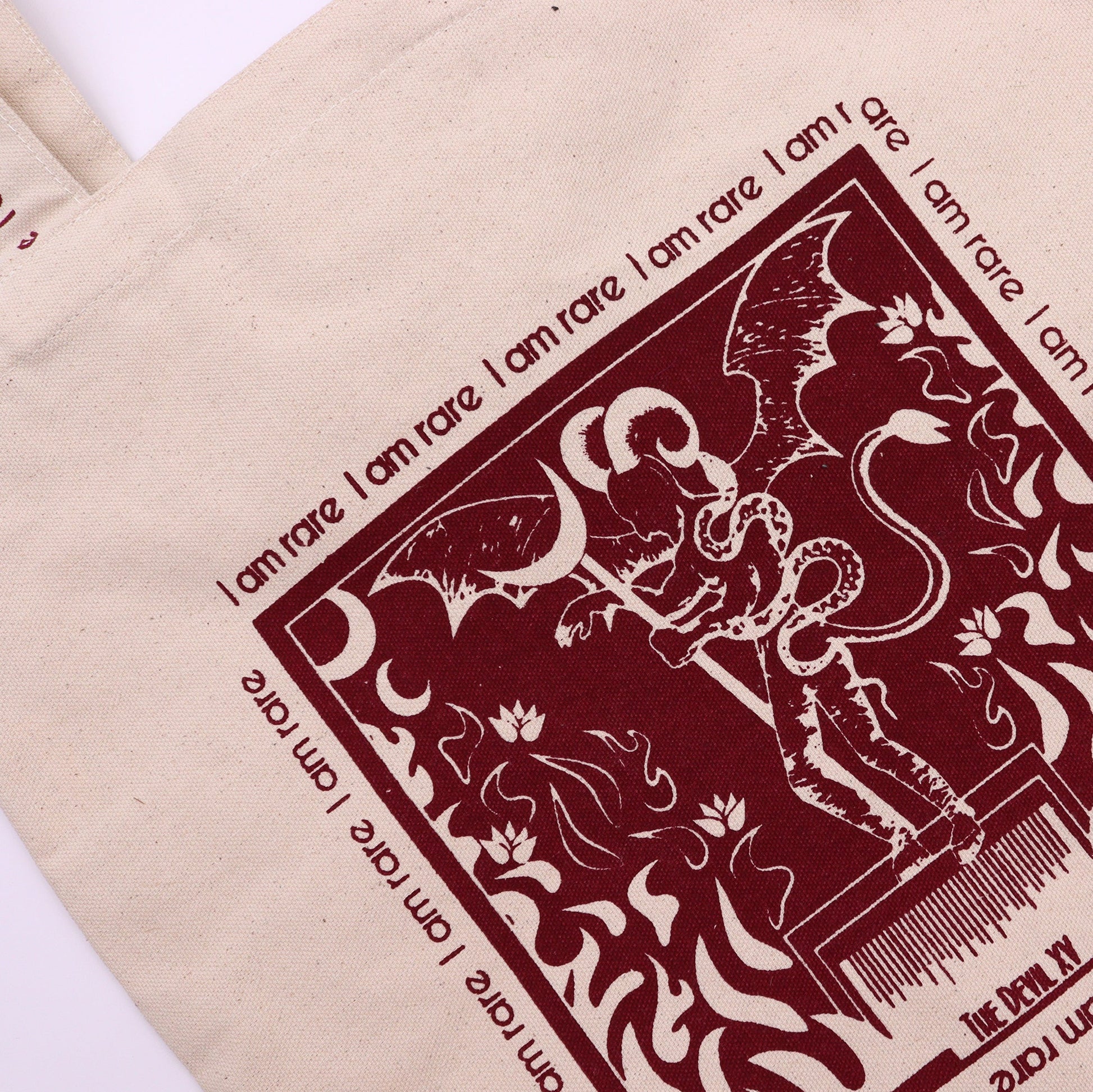 Devil Tarot Card Cotton Canvas Tote Bag - I Am Rare with a close-up burgundy illustration of a horned figure by Quintessential Holistic Health Ltd