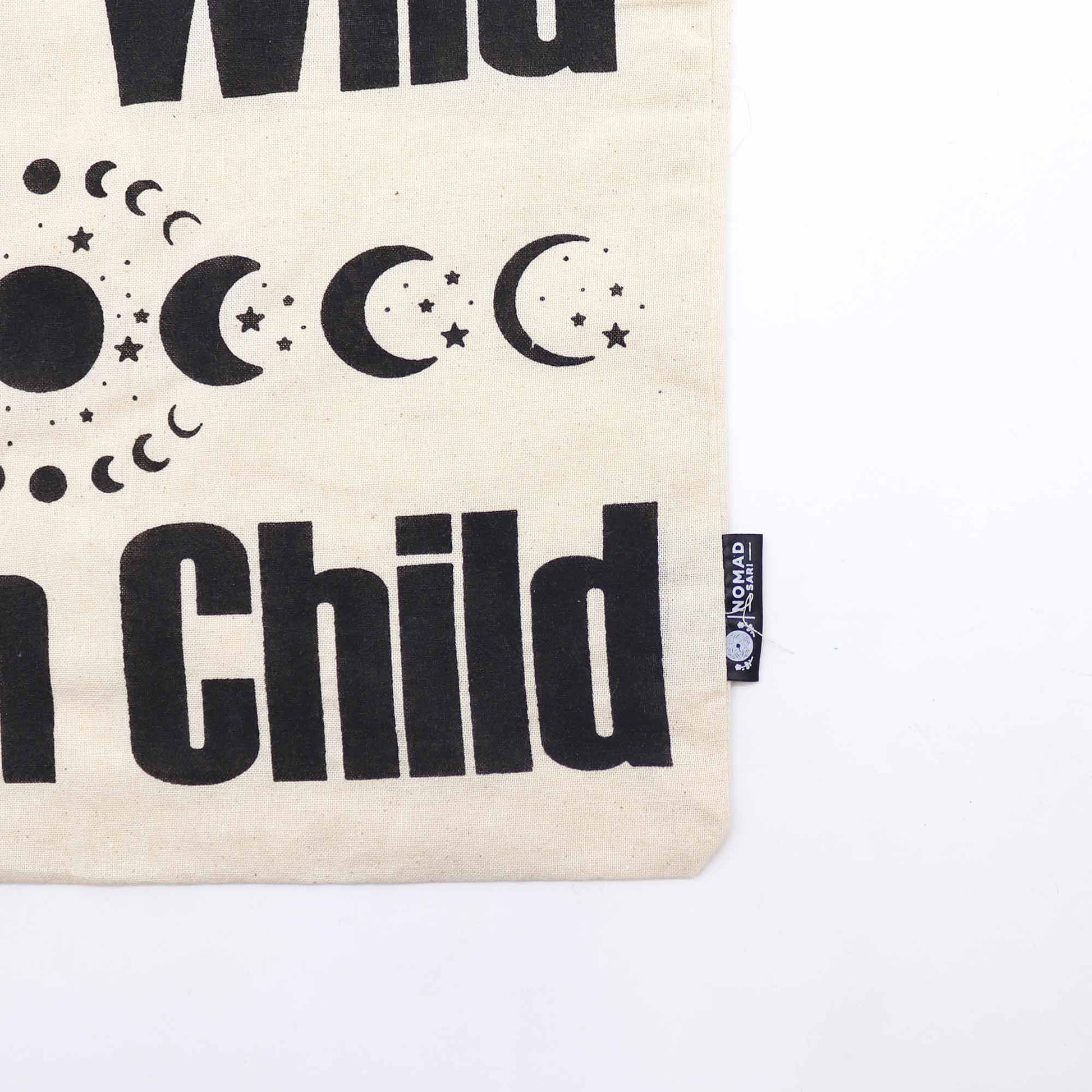 Iconic Natural Cotton Tote Bag - Stay Wild Moon Child - Natural, close-up of moon phases, stars, lettering and side label by Quintessential Holistic Health Ltd