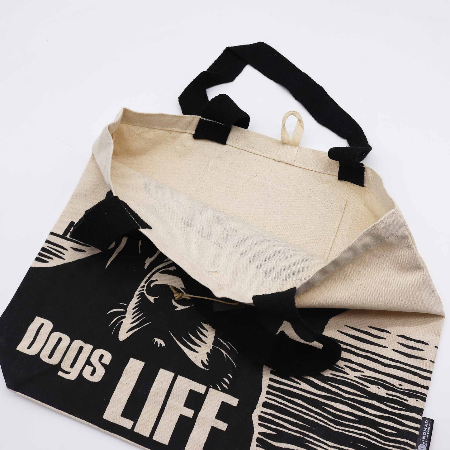 Cotton Classic Tote Bag - It's a Dog's Life - Black & Natural, shown open and folded with the dog design partly visible by Quintessential Holistic Health Ltd