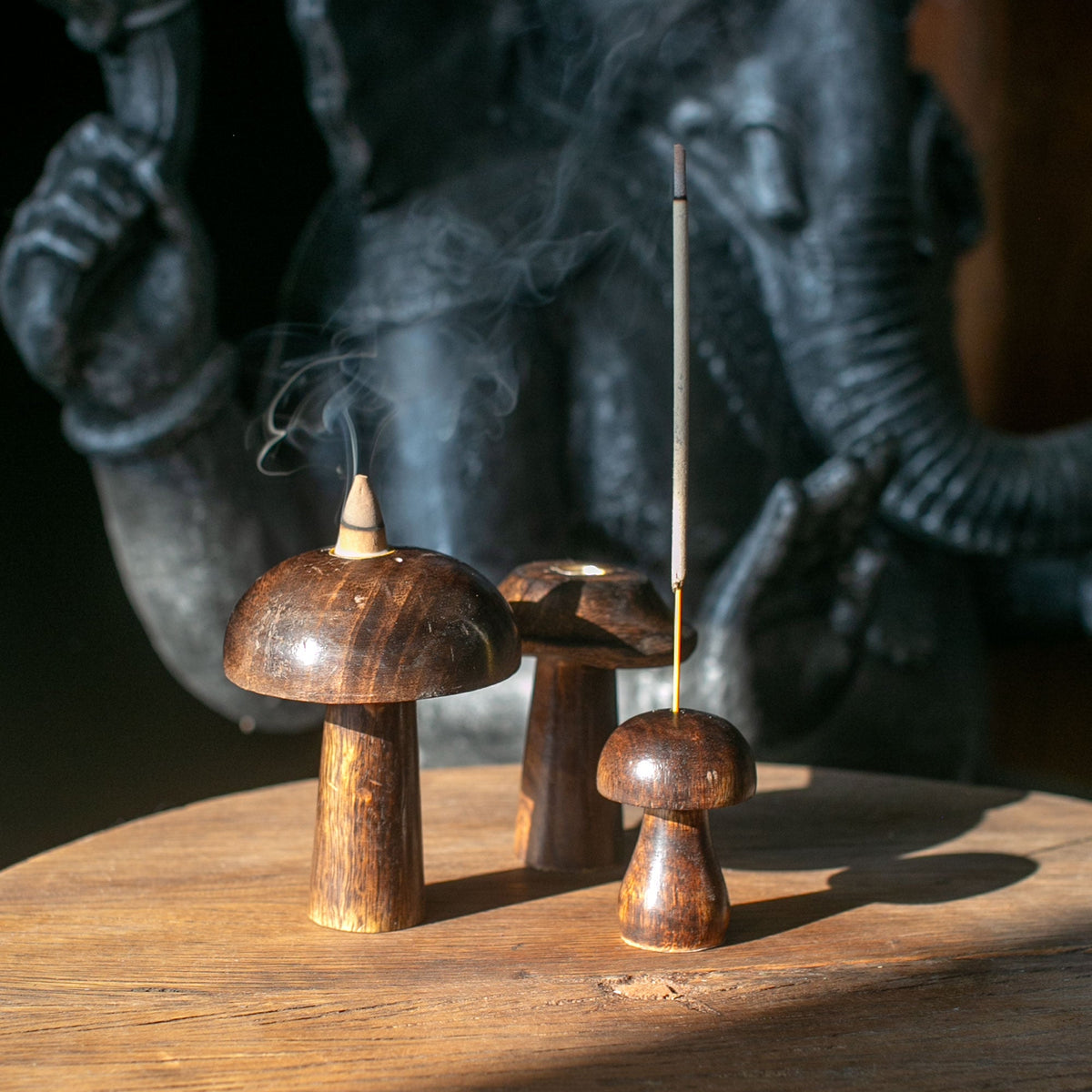 Set of 3 Mango Wood Incense Holders - Button Mushrooms, three rounded pieces holding two upright sticks with visible smoke by Quintessential Holistic Health Ltd
