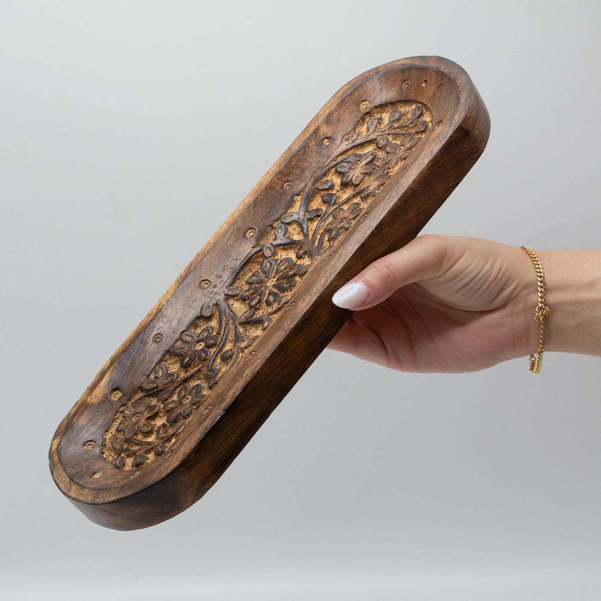 Mango Wood Dual Incense Tray - Flower Design, held in one hand with an ornate carved floral centre and raised rim by Quintessential Holistic Health Ltd
