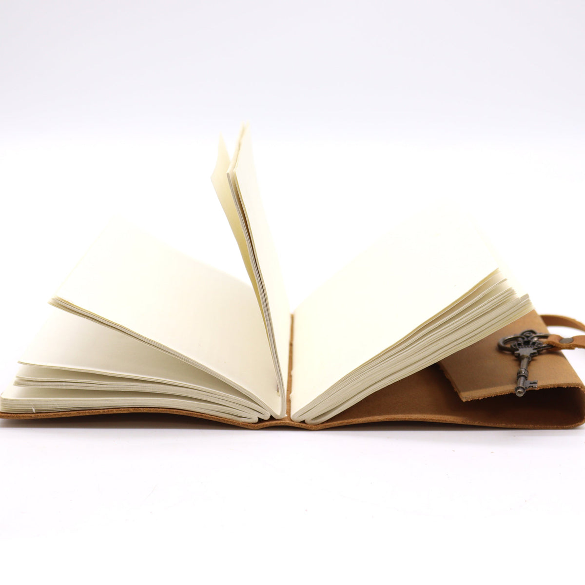 Oiled Leather 200-Page Notebook with Strap & Key – Medium Tan open to blank cream pages with the strap and key charm visible by Quintessential Holistic Health Ltd