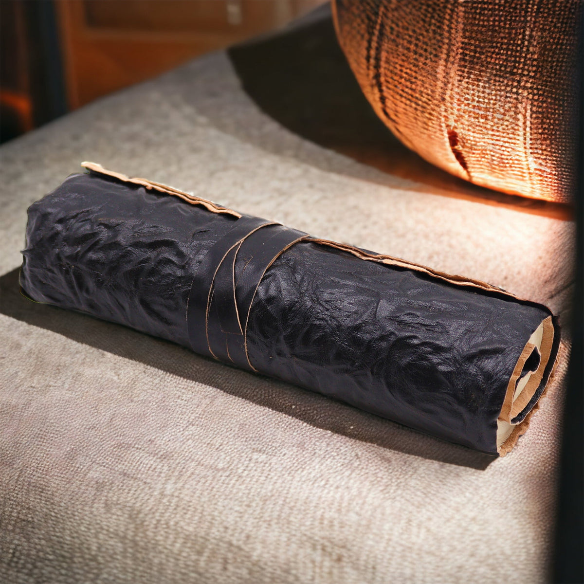 Handmade Rolled Leather Travel Notebook with Strap - Black, rolled in a textured black wrap with a thin cord tie by Quintessential Holistic Health Ltd