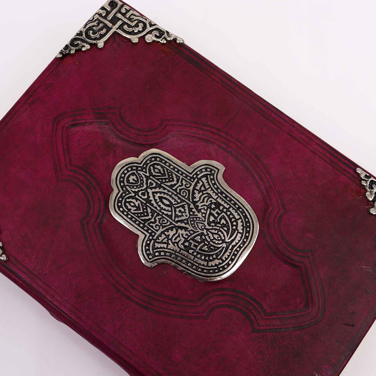 Extra-Large Burgundy Leather Deckle-Edged Journal - Zinc Hamsa, close-up of burgundy cover with central Hamsa emblem and ornate corners by Quintessential Holistic Health Ltd