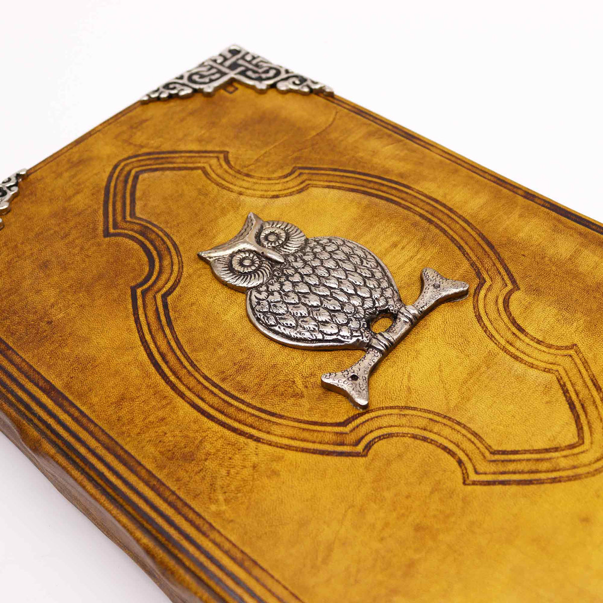 Extra-Large Tan Leather Deckle-Edged Journal - Zinc Owl, close-up of the owl emblem, embossed cover and ornate corner by Quintessential Holistic Health Ltd