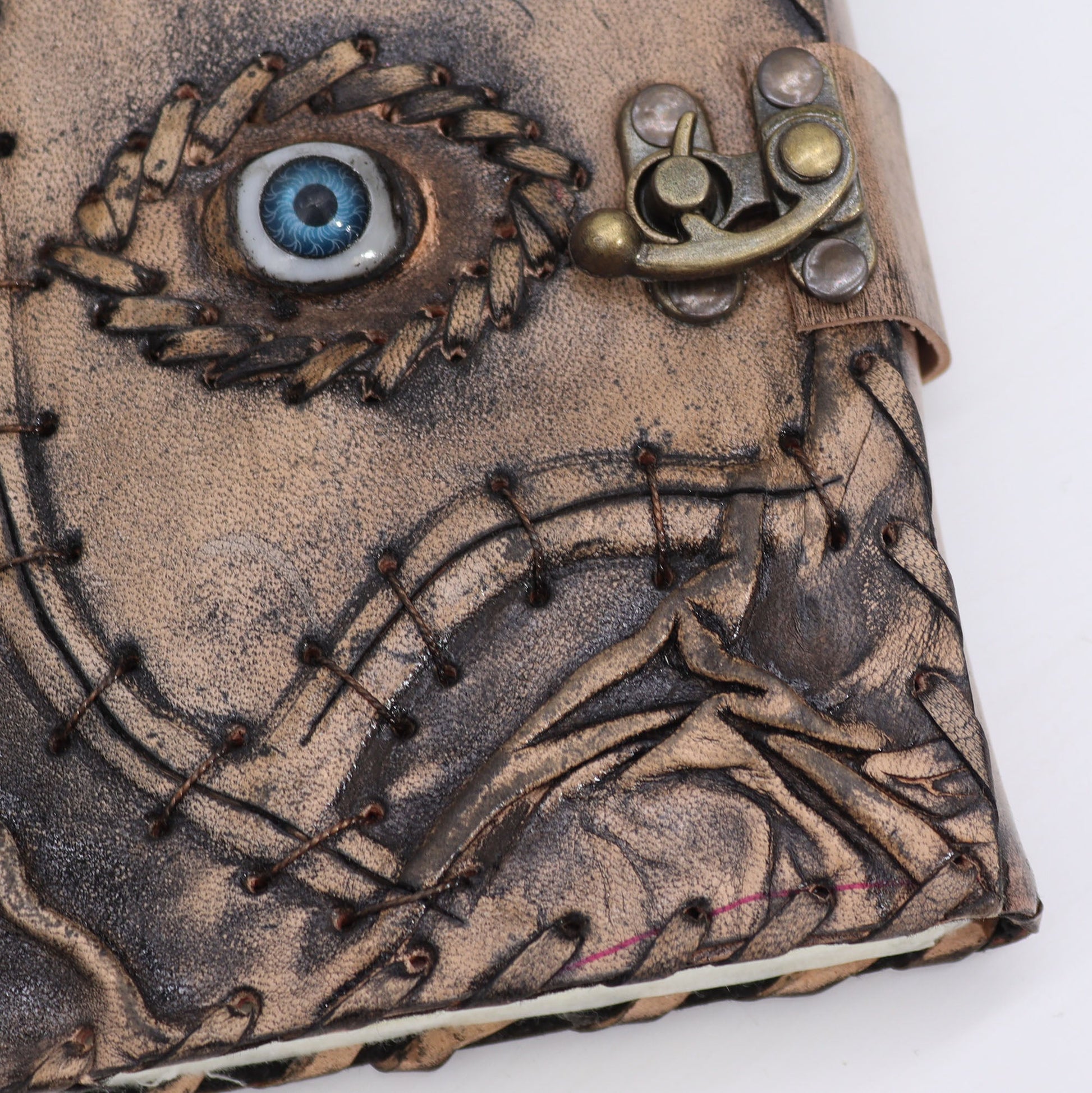 Medium Tan Leather Notebook - Evil Eye - 160 Deckle-Edged Pages, close view of the blue eye, stitching and clasp, by Quintessential Holistic Health Ltd