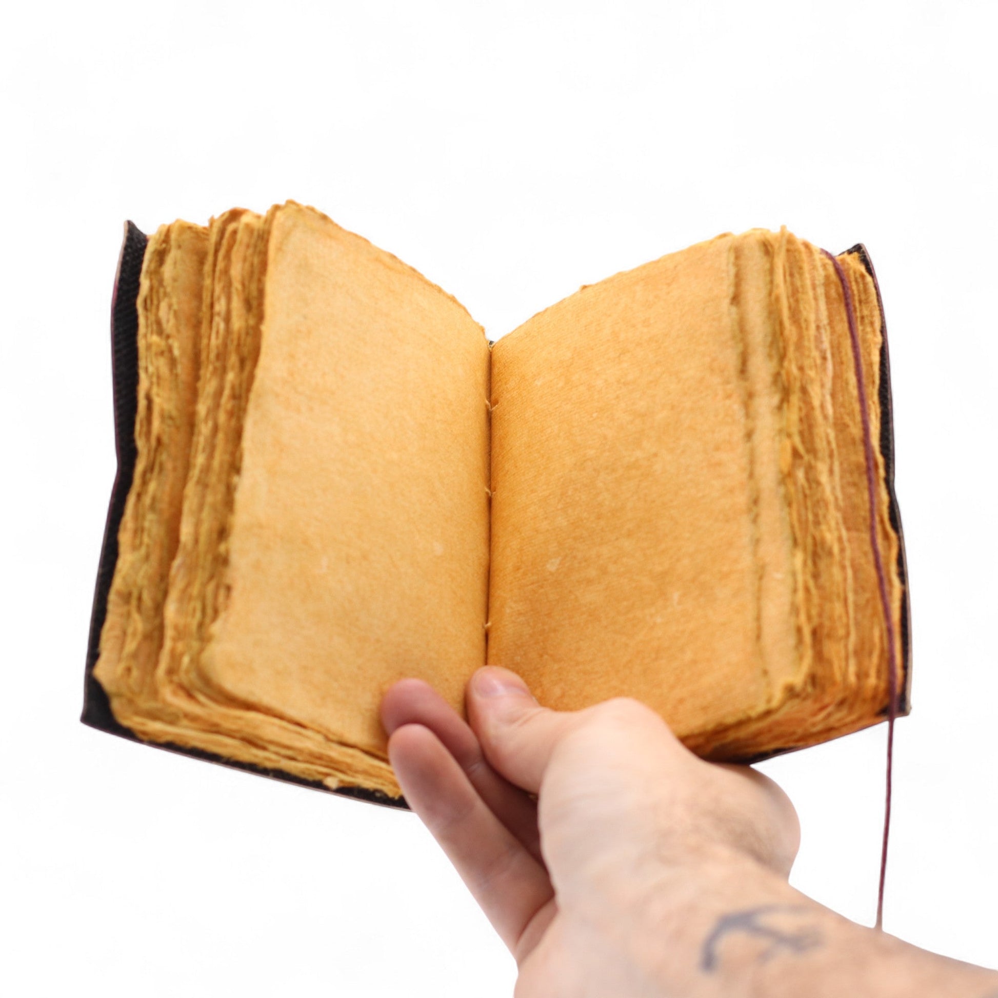 Small Brown Deckle-Edged Leather Wrap Journal - Good in Every Day held open to blank golden deckle-edged pages by Quintessential Holistic Health Ltd