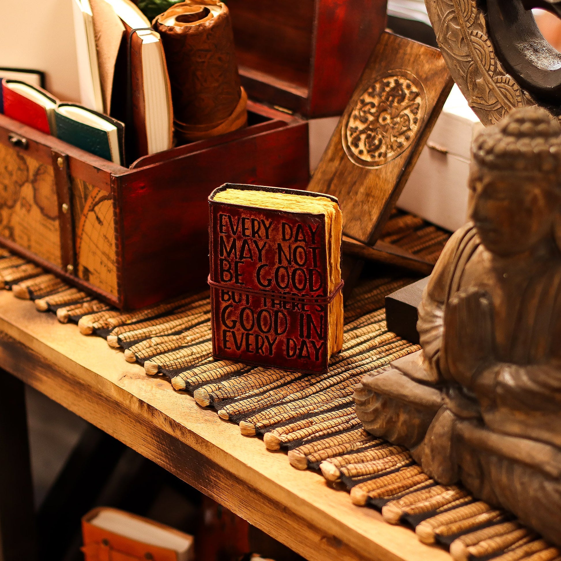 Small Brown Deckle-Edged Leather Wrap Journal - Good in Every Day standing closed on a display shelf with black cover lettering by Quintessential Holistic Health Ltd