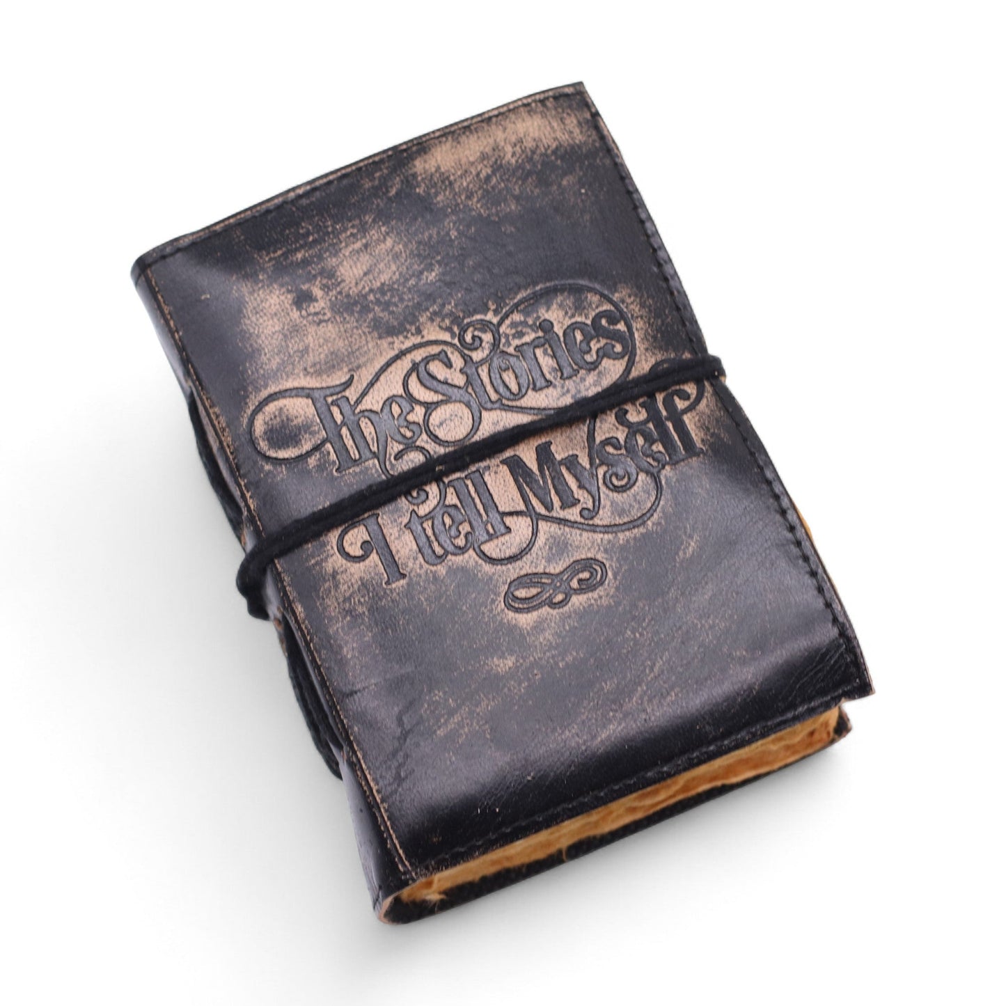 Small Black and Tan Leather Journal - The Stories I Tell Myself angled to show ornate cover lettering and golden page edges by Quintessential Holistic Health Ltd