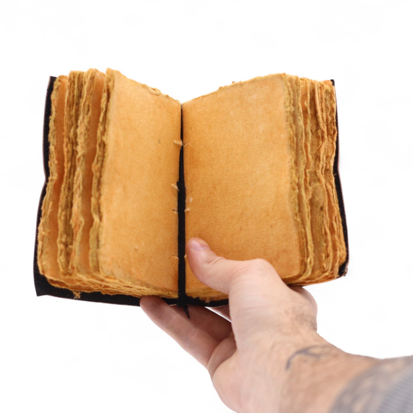 Small Black and Tan Leather Journal - The Stories I Tell Myself, held open to blank tan pages with uneven edges by Quintessential Holistic Health Ltd