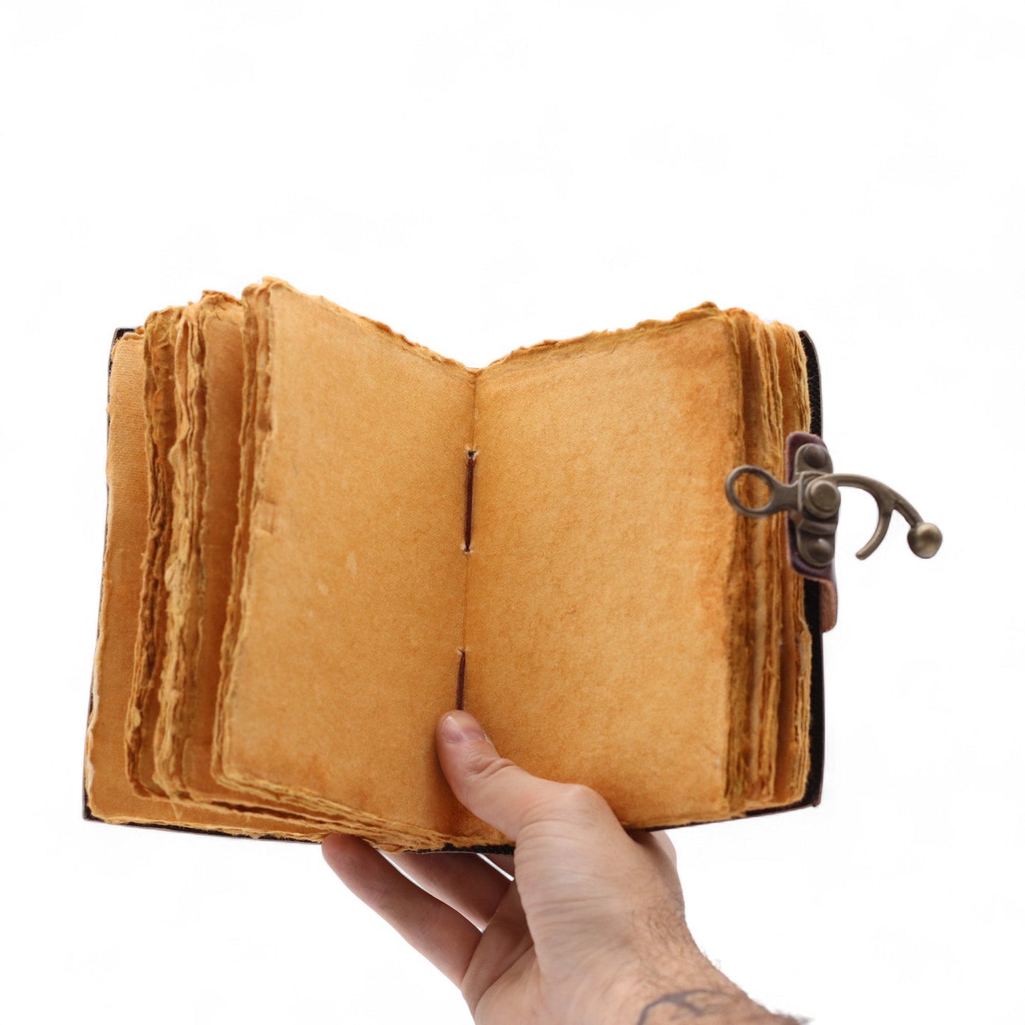 Small Brown Leather Journal - The Book of Untold Stories, held open to blank tan pages with uneven layered edges by Quintessential Holistic Health Ltd