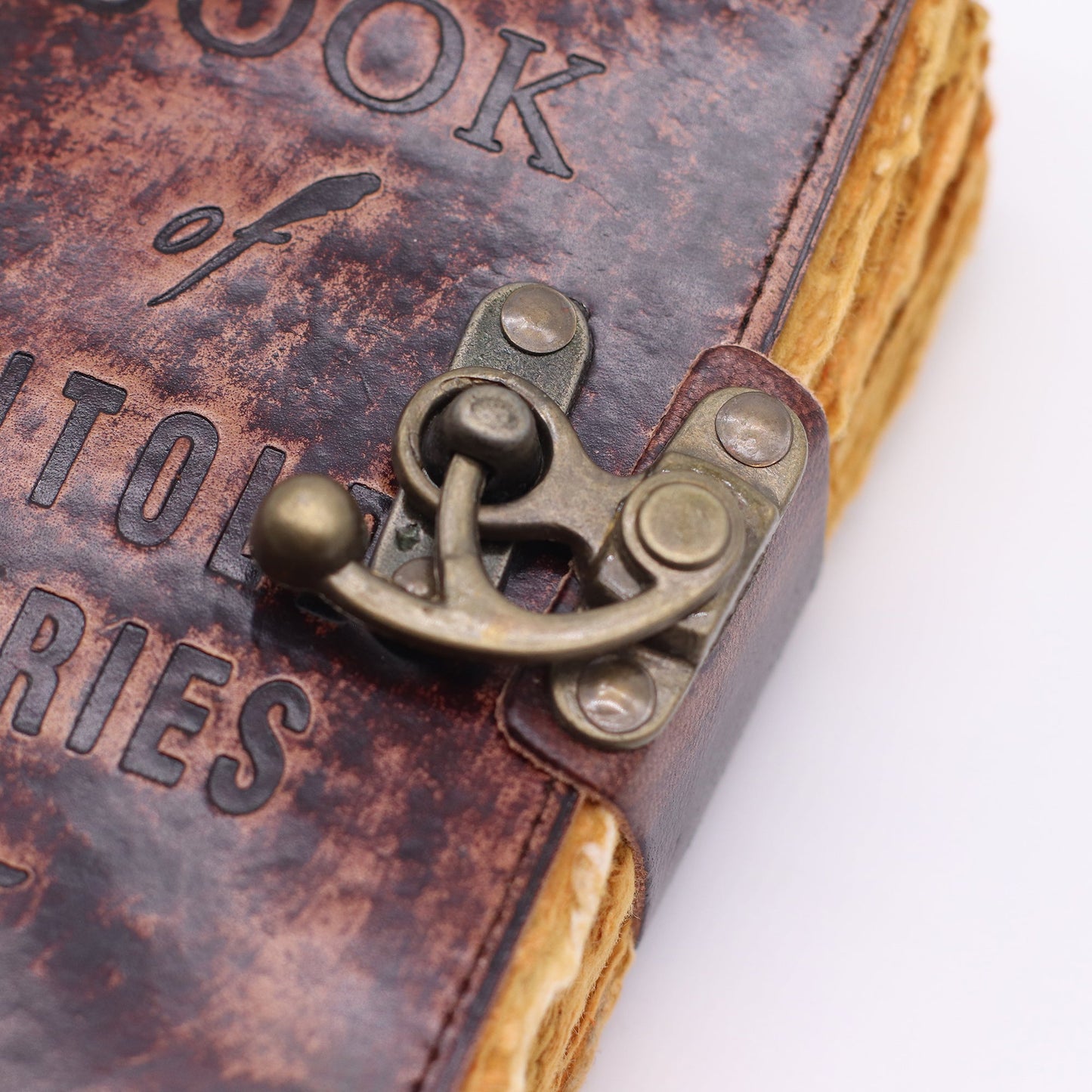 Small Brown Leather Journal - The Book of Untold Stories, close-up of embossed cover lettering and the ornate metal clasp by Quintessential Holistic Health Ltd