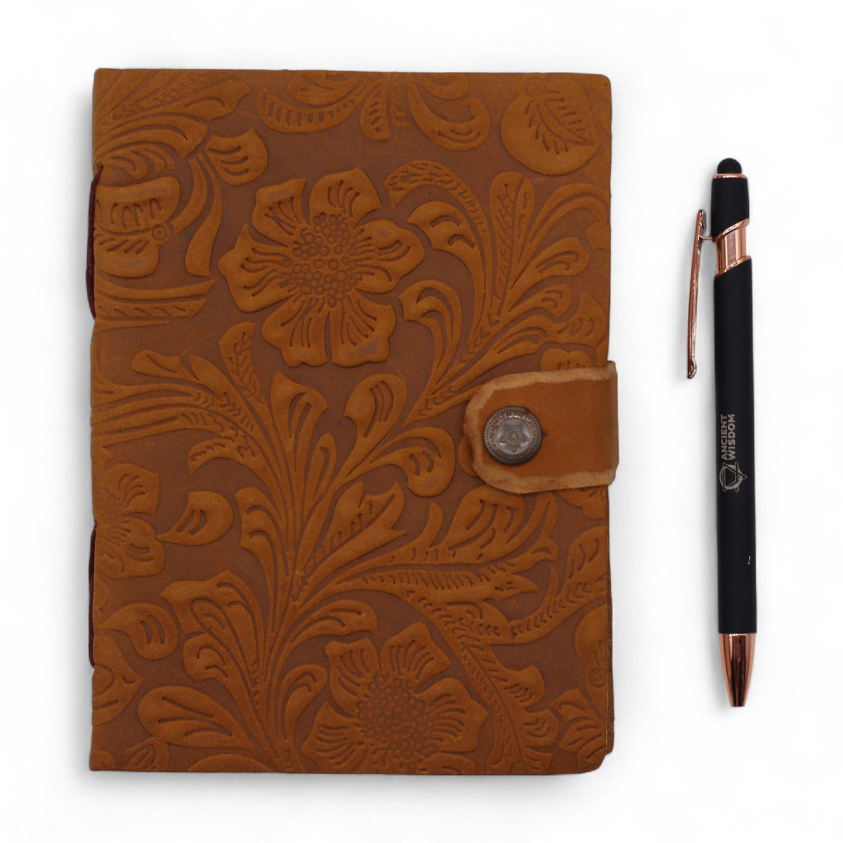 Leather-Bound Floral Notebook - Medium Tan, Strap, 200 Pages shown closed beside a black pen with embossed floral cover by Quintessential Holistic Health Ltd